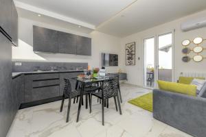 een keuken en een woonkamer met een tafel en stoelen bij MGH Porto Deluxe Apartment in Sirmione