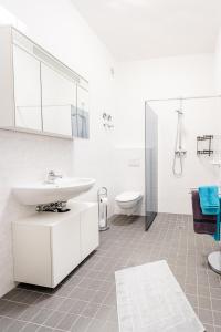a white bathroom with a sink and a toilet at Ferienwohnungen direkt am Werbellinsee in Joachimsthal