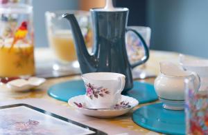 uma mesa com um bule de chá, uma chávena e pires em Wildwood B&B em Lymington