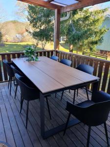 a wooden table and chairs on a deck at Hela boendet uthyres in Överlida