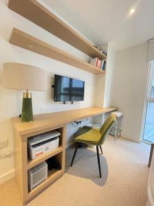 a room with a desk with a television and a chair at Westminster-Gem in London