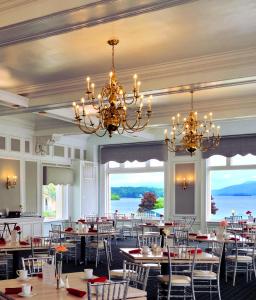 a dining room with tables and chairs and chandeliers at Fort William Henry Hotel in Lake George