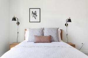 a bedroom with a white bed with two lamps at Porter Sq 2BR w WD Elevator by Davis Station BOS-319 in Somerville +11 photos