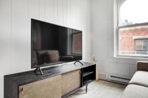 a living room with a large flat screen tv at Cozy N End 2BR steps from Harborwalk BOS-449 in Boston