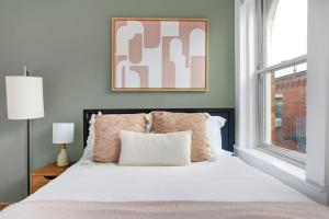 a bedroom with a large bed with a window at Cozy N End 2BR steps from Harborwalk BOS-449 in Boston