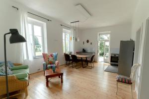 ein Wohnzimmer mit einem Tisch und Stühlen sowie eine Küche in der Unterkunft Villa Schwertführer in Velden am Wörthersee