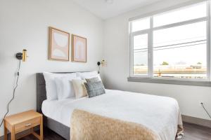 a white bedroom with a bed and a window at New build Sommerville 2BR w Rooftop WD in unit BOS-366 in Somerville