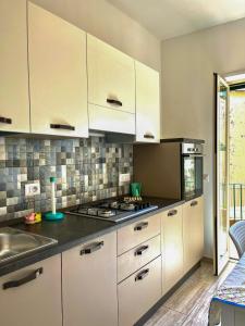 a kitchen with white cabinets and a sink at Il Rifugio Dei Partenopei in Naples