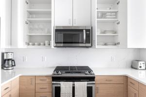 a kitchen with a stove and a microwave at 1BR w Gym WD Steps from Newtonville Train BOS-353 in Newton +31 photos