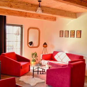salon z 2 czerwonymi krzesłami i stołem w obiekcie Rezidence Valcha w mieście Sušice