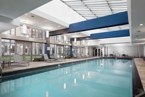 a large swimming pool in a large building at E Cambridge 1BR w WD Gym steps from Train BOS-524 in Boston