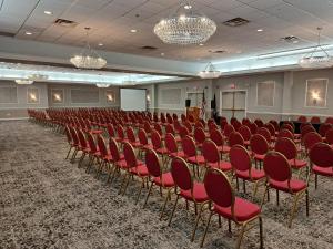 a conference room with red chairs and a podium at Fort William Henry Hotel in Lake George