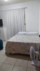 a bedroom with a bed and a fan in it at 3 Kitnets in Rio das Ostras