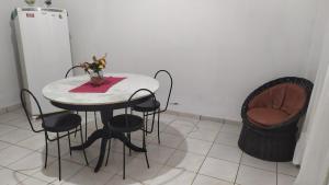a table and chairs with a vase of flowers on it at 3 Kitnets in Rio das Ostras