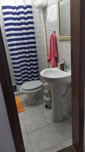 a bathroom with a sink and a toilet and a shower at 3 Kitnets in Rio das Ostras
