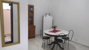 a dining room with a table and a mirror at 3 Kitnets in Rio das Ostras