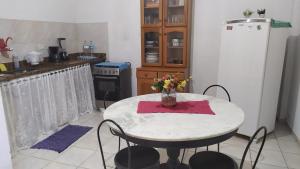 a kitchen with a table with a vase of flowers on it at 3 Kitnets in Rio das Ostras