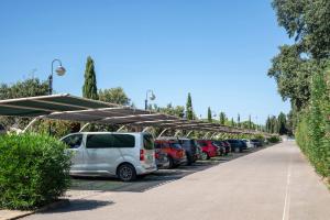 una fila de autos estacionados en un estacionamiento en Villaggio Il Girasole, en Follonica