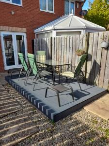 a patio with a table and chairs and an umbrella at Perfectly placed 3 bed home in a peaceful close in Darlington