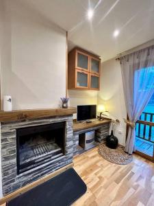 uma sala de estar com lareira e televisão em L'allotjament rústic d'Ainet em Vall de Cardos