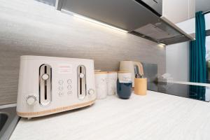 a toaster sitting on a counter in a kitchen at One bed flat with additional double mattress suitable for 4 in Hayes