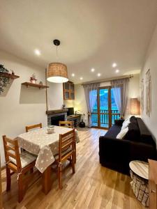 uma sala de estar com uma mesa e um sofá em L'allotjament rústic d'Ainet em Vall de Cardos