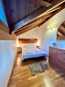 1 dormitorio con cama y techo de madera en L'allotjament rústic d'Ainet, en Vall de Cardós