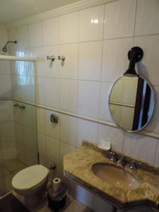 a bathroom with a sink and a toilet and a mirror at Casa Canto do Mar Maresias 2 in Maresias