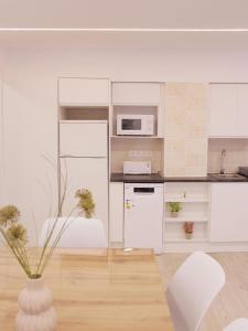 una cocina con armarios blancos y un jarrón con flores. en Cuenca Home, en Cuenca