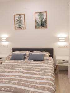 1 dormitorio con 1 cama con 2 cuadros en la pared en Cuenca Home, en Cuenca