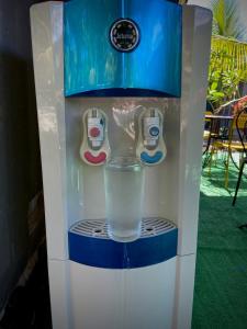 eine Wassermaschine mit einem Glas Wasser in der Unterkunft Rooms & Pool Macaws in Uvita