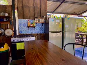 eine Küche mit einem Holztisch und einem Kühlschrank in der Unterkunft Rooms & Pool Macaws in Uvita