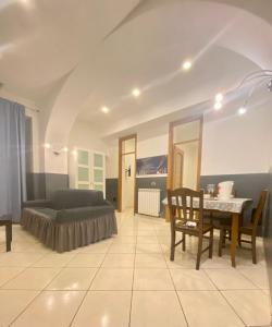 ein Wohnzimmer mit einem Bett, einem Tisch und einem Sofa in der Unterkunft POSILLIPO 27 in Neapel