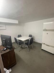 Habitación con mesa, sillas y nevera. en Silencioso con patio en Buenos Aires