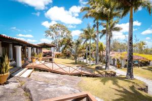 a resort with palm trees and a walkway at Hotel Highlander in Gravatá