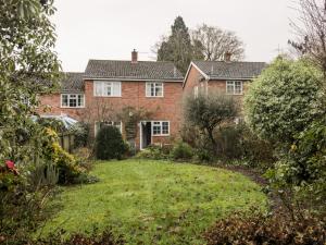 a large red brick house with a yard at Poets Corner in Great Malvern