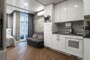a kitchen with white cabinets and a bed in a room at Luxury Studio Silver in Sofia