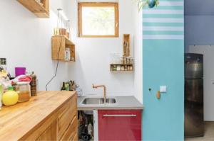 a kitchen with a sink and a refrigerator at Charmante chambre double chez l'habitant in Pantin