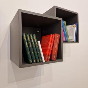 a book shelf filled with books on a wall at B&B UNICI in Grammichele