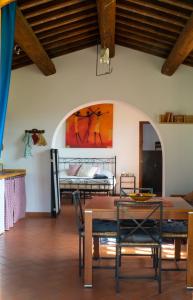 een kamer met een tafel en stoelen en een bed bij Agriturismo Podere le Fornaci in Greve in Chianti