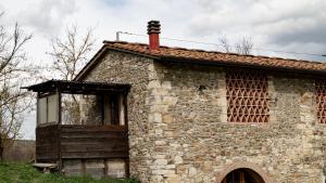 een oud stenen gebouw met een schoorsteen en een raam bij Agriturismo Podere le Fornaci in Greve in Chianti