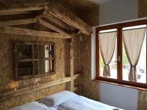a bedroom with a bed and a window at Ca' Romantica - Ledro House in Pieve Di Ledro