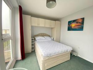 um pequeno quarto com uma cama e uma janela em Charming Spacious 3-bedroom Beach Holiday House, Norfolk em Hemsby