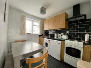 uma cozinha com uma mesa e um fogão forno superior em Charming Spacious 3-bedroom Beach Holiday House, Norfolk em Hemsby