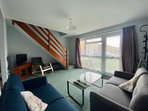 a living room with a couch and a glass table at Charming Spacious 3-bedroom Beach Holiday House, Norfolk in Hemsby