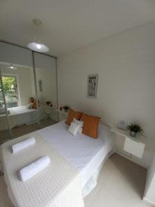 Habitación blanca con cama y espejo en Palermo House en Buenos Aires