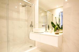 a white bathroom with a sink and a shower at Tower View - Apartamento superior no centro de Aveiro in Aveiro +11 photos