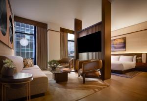 a hotel room with a couch and a bed and a tv at Nobu Hotel Atlanta in Atlanta