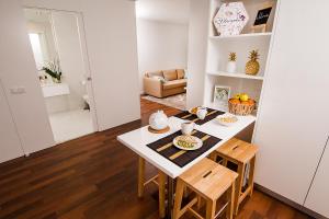 Il comprend une petite cuisine et une salle à manger avec une table et des chaises. dans l'établissement Tower View - Apartamento superior no centro de Aveiro, à Aveiro
