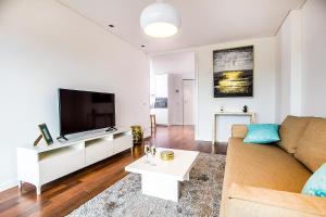 a living room with a couch and a flat screen tv at Tower View - Apartamento superior no centro de Aveiro in Aveiro